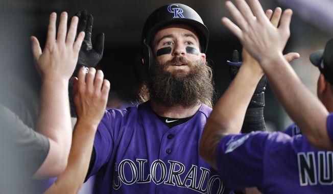 Colorado Rockies&#x27; Charlie Blackmon is congratulated as he returns to the dugout after hitting a solo home run off San Diego Padres starting pitcher Eric Lauer during the third inning of a baseball game Saturday, Sept. 14, 2019, in Denver. (AP Photo/David Zalubowski)