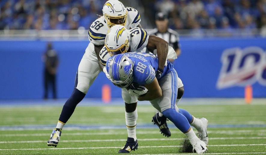 Detroit Lions tight end T.J. Hockenson (88) is brought down by Los Angeles Chargers defensive back Adrian Phillips (31) and Thomas Davis (58) in the first half of an NFL football game in Detroit, Sunday, Sept. 15, 2019. (AP Photo/Duane Burleson)