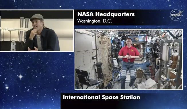 In this image taken from NASA video actor Brad Pitt, left, star of the new space movie “Ad Astra,” speaks from NASA headquarters in Washington, to astronaut Nick Hague abroad the International Space Station, on Monday, Sept. 16, 2019. (NASA via AP)