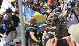 In this Aug. 12, 2017 file photo, white nationalist demonstrators clash with counter-demonstrators at the entrance to Lee Park in Charlottesville, Va.  (AP Photo/Steve Helber, File) **FILE**