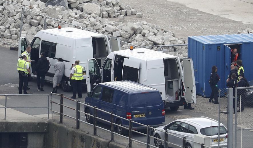 In this file photo, a group of people thought to be migrants are brought to shore by Border Force officers after a small boat incident in the English Channel at the Port of Dover in Kent, England. Monday Sept. 16, 2019. (Gareth Fuller/PA via AP) **FILE**
