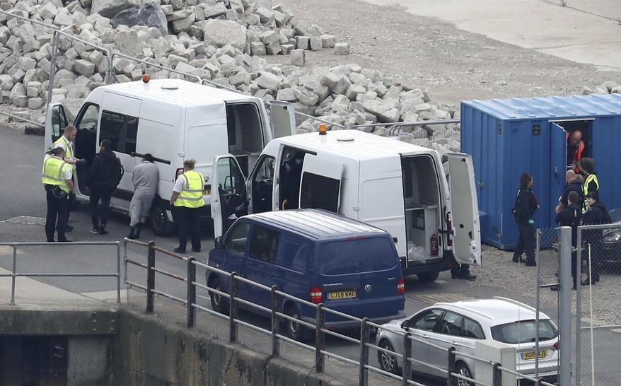 In this file photo, a group of people thought to be migrants are brought to shore by Border Force officers after a small boat incident in the English Channel at the Port of Dover in Kent, England. Monday Sept. 16, 2019. (Gareth Fuller/PA via AP) **FILE**