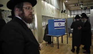 Ultra orthodox Jews wait for Rabbi Israel Hager to vote in Bnei Brak, Israel, Tuesday, Sept. 17, 2019. Israelis began voting Tuesday in an unprecedented repeat election that will decide whether longtime Prime Minister Benjamin Netanyahu stays in power despite a looming indictment on corruption charges. (AP Photo/Oded Balilty)