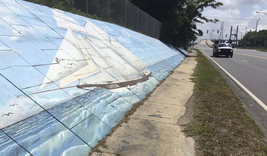 FILE - In this May 30, 2019, file photo, traffic passes a mural of the slave ship Clotilda along Africatown Blvd. in Mobile, Ala. Alabama's historical agency is one step closer to taking permanent possession of the ship's wreckage since no one met a court deadline for claiming ownership of the remains, which were found in delta waters near the port city. (AP Photo/Kevin McGill, File)