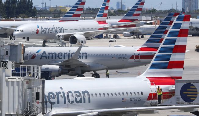 In this April 24, 2019, photo, American Airlines aircraft are shown parked at their gates at Miami International Airport in Miami. (AP Photo/Wilfredo Lee, File)