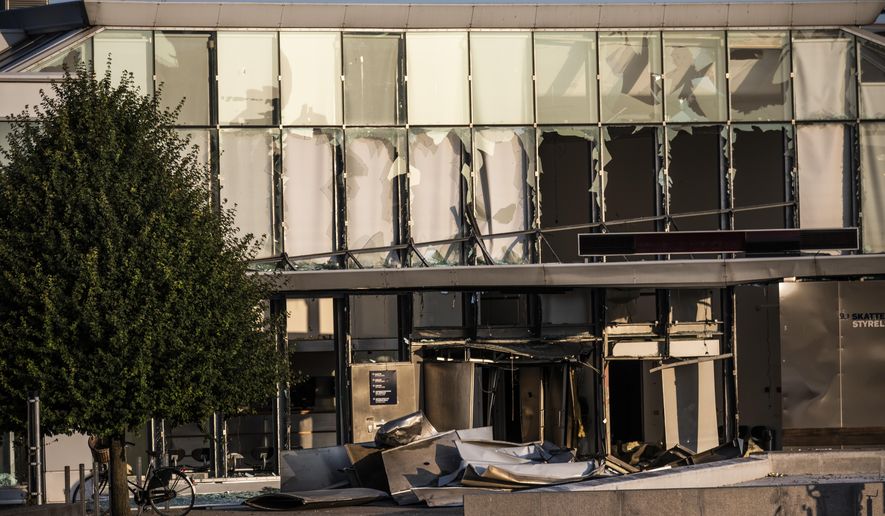 FILE - This Wednesday, Aug. 7, 2019 file photo, shows a view of the damage caused by an explosion to the entrance of the Danish Tax Authority in Copenhagen, Denmark. Police in Denmark say they have arrested a 23-year-old man late Tuesday Sept. 17, 2019, as a suspect in the explosion that damaged the headquarters of the Danish Tax Agency and slightly injured a bystander last month. (Olafur Steinar Rye Gestsson/Ritzau Scanpix via AP, File)