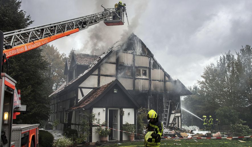 Firefigthers extinguish a fire in a house in Muenster, Germany, Wednesday, Sept. 18, 2019. Two women and a police officer where injured by an exploion inside the house. (Bernd Thissen/dpa via AP)
