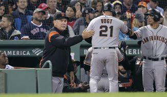 San Francisco Giants&#39; Stephen Vogt (21) gets a pat on the back from manager Bruce Bochy, left, after his sacrifice that scored Kevin Pillar during the eighth inning of a baseball game against the Boston Red Sox at Fenway Park in Boston, Wednesday, Sept. 18, 2019. (AP Photo/Charles Krupa)