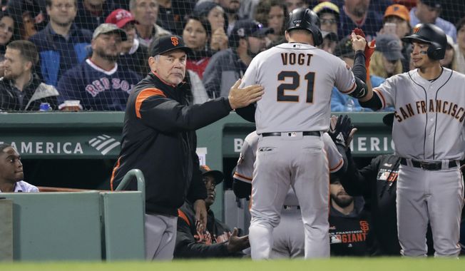 San Francisco Giants&#x27; Stephen Vogt (21) gets a pat on the back from manager Bruce Bochy, left, after his sacrifice that scored Kevin Pillar during the eighth inning of a baseball game against the Boston Red Sox at Fenway Park in Boston, Wednesday, Sept. 18, 2019. (AP Photo/Charles Krupa)
