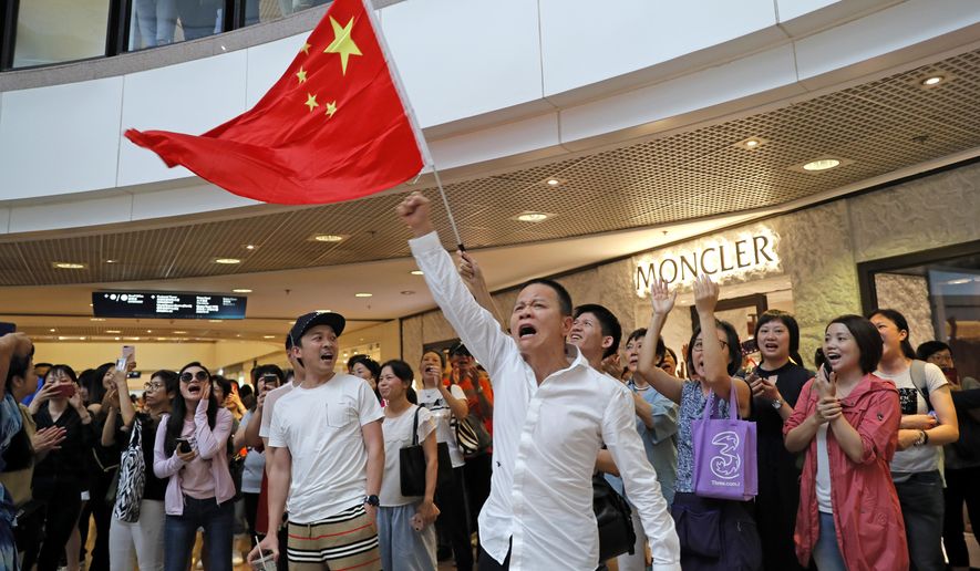 Pro-China supporters wave a Chinese national flag in a shopping mall in Hong Kong, Wednesday, Sept. 18, 2019. Activists involved in the pro-democracy protests in Hong Kong appealed to U.S. lawmakers Tuesday to support their fight by banning the export of American police equipment that is used against demonstrators and by more closely monitoring Chinese efforts to undermine civil liberties in the city. (AP Photo/Kin Cheung)