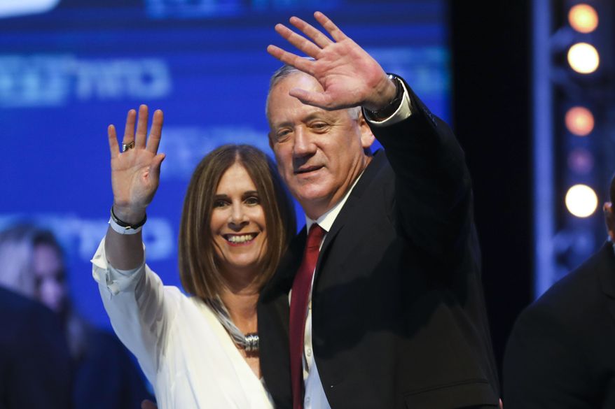 Blue and White party leader Benny Gantz and his wife Revital wave to supporters at party headquarters after the first results of the elections in Tel Aviv, Israel, Wednesday, Sept. 18, 2019. (AP Photo/Oded Balilty)
