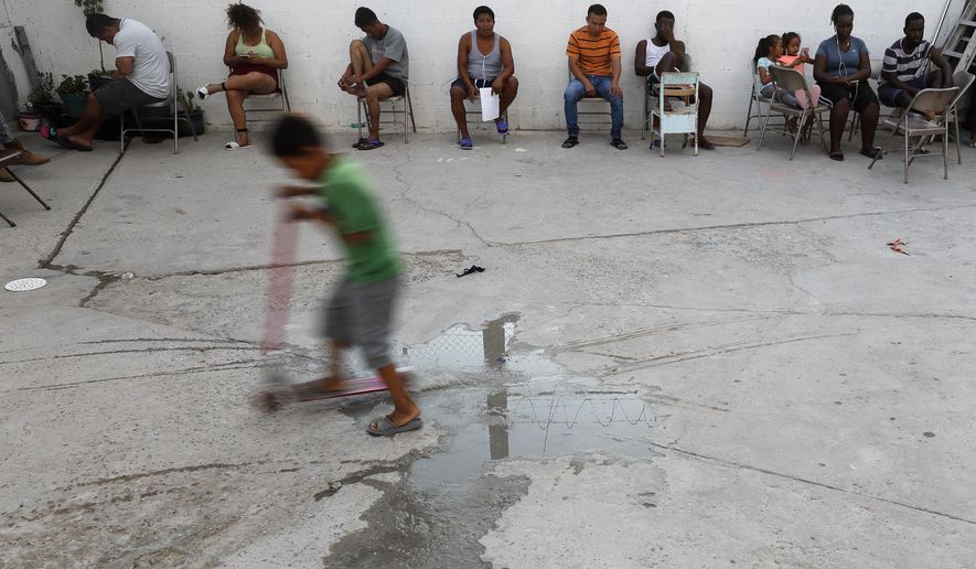 In this July 26, 2019, photo, people from Africa and Central America sit in chairs as the sun sets at El Buen Pastor shelter for migrants in Cuidad Juarez, Mexico. (AP Photo/Gregory Bull)