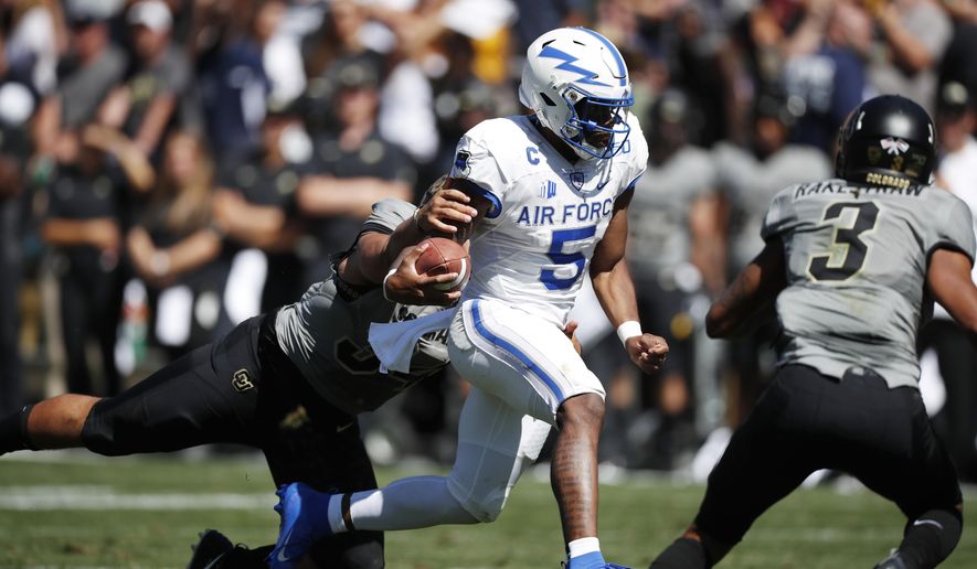 Air Force quarterback Donald Hammond III, center, drives for a short gain as Colorado safety Sam Noyer, left, and safety Derrion Rakestraw cover in the second half of an NCAA college football game Saturday, Sept. 14, 2019, in Boulder, Colo. Air Force won 30-23 in overtime. (AP Photo/David Zalubowski)