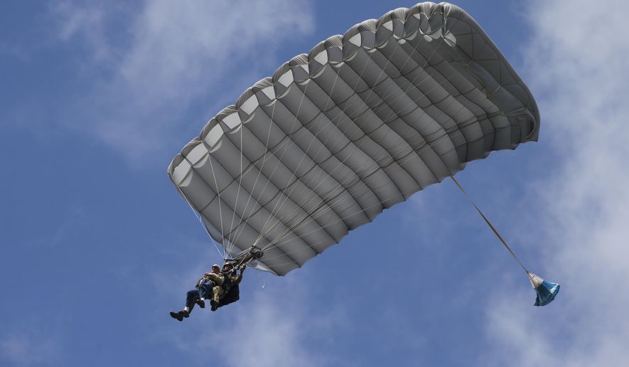 Tom Rice, a 98-year-old American WWII veteran, front left, approaches the landing zone during a tandem parachute jump near Groesbeek, Netherlands, Thursday, Sept. 19, 2019, as part of commemorations marking the 75th anniversary of Operation Market Garden. Rice jumped with the U.S. Army&#39;s 101st Airborne Division in Normandy, landing safely despite catching himself on the exit and a bullet striking his parachute. (AP Photo/Peter Dejong)