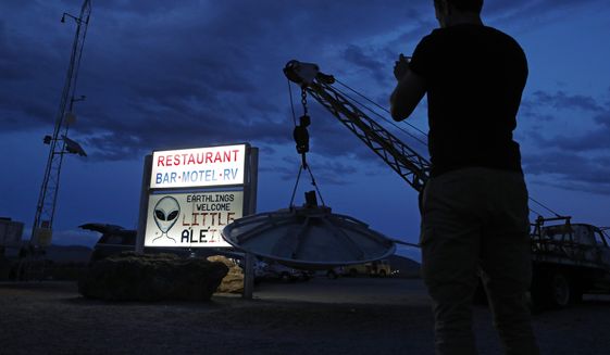 A man takes a picture of a sign at the Little A&#39;Le&#39;Inn during an event inspired by the &amp;quot;Storm Area 51&amp;quot; internet hoax, Thursday, Sept. 19, 2019, in Rachel, Nev. Hundreds have arrived in the desert after a Facebook post inviting people to &amp;quot;see them aliens&amp;quot; got widespread attention and gave rise to festivals this week. (AP Photo/John Locher)