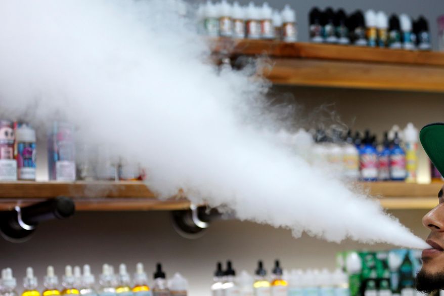 In this Tuesday, Sept. 3, 2019, file photo, a salesman at a vape shop exhales while using an e-cigarette in Maine. On Thursday, Sept. 19, 2019, the U.S. Centers for Disease Control and Prevention said 530 confirmed and probable cases have been reported from 38 states and one U.S. territory. (AP Photo/Robert F. Bukaty)