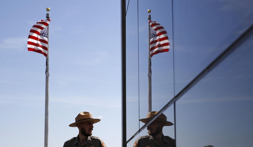 A National Park Service park ranger is reflected in the glass wall of a new security screening building at the foot of the Washington Monument following a ribbon-cutting ceremony to re-open the monument with first lady Melania Trump, Thursday, Sept. 19, 2019, in Washington. (AP Photo/Patrick Semansky) **FILE**