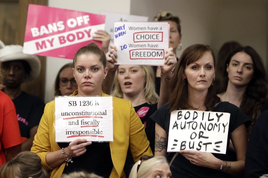 FILE - In this Aug. 12, 2019 file photo, people wait for a Senate hearing to begin to discuss a fetal heartbeat abortion ban, or possibly something more restrictive in Nashville, Tenn. Four years after Tennessee passed a law requiring a 48-hour waiting period for women seeking abortions, a lawsuit challenging the statute’s constitutionality is finally going to trial. Beginning Monday, Sept. 23, attorneys for five of the state’s seven abortion clinics will argue in federal court that the law harms the women it is supposed to help.(AP Photo/Mark Humphrey)