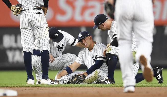 New York Yankees second baseman Gleyber Torres sits on the ground after slipping while trying to field a ground ball during the fourth inning of the team&#x27;s baseball game against the Toronto Blue Jays, Friday, Sept. 20, 2019, in New York. (AP Photo/Sarah Stier)