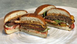 FILE - This Friday, May 3, 2019 file photo shows an Original Impossible Burger, left, and a Cali Burger, from Umami Burger, in New York. A new era of meat alternatives is here, with Beyond Meat becoming the first vegan meat company to go public and Impossible Burger popping up on menus around the country. Several new vegetarian products are competing to win over meat lovers, but two California companies _ Impossible Foods and Beyond Meat _ are grabbing attention for patties that are red before they’re cooked, making them resemble raw beef. (AP Photo/Richard Drew)