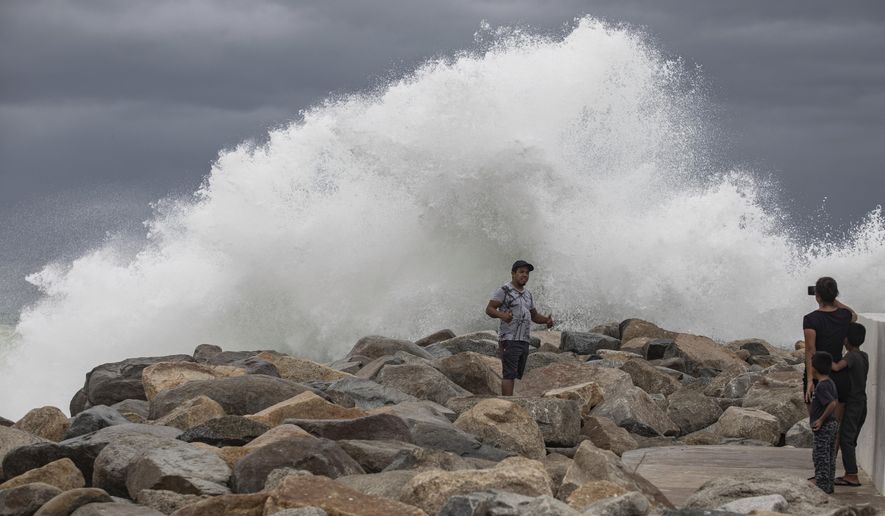 A tourist poses for a photo in front breaking waves before the expected arrival of Hurricane Lorena, in Los Cabos, Mexico, Friday, Sept. 20, 2019. Hurricane Lorena neared Mexico&#x27;s resort-studded Los Cabos area Friday as owners pulled their boats from the water, tourists hunkered down in hotels, and police and soldiers went through low-lying, low-income neighborhoods urging people to evacuate. (AP Photo/Fernando Castillo)