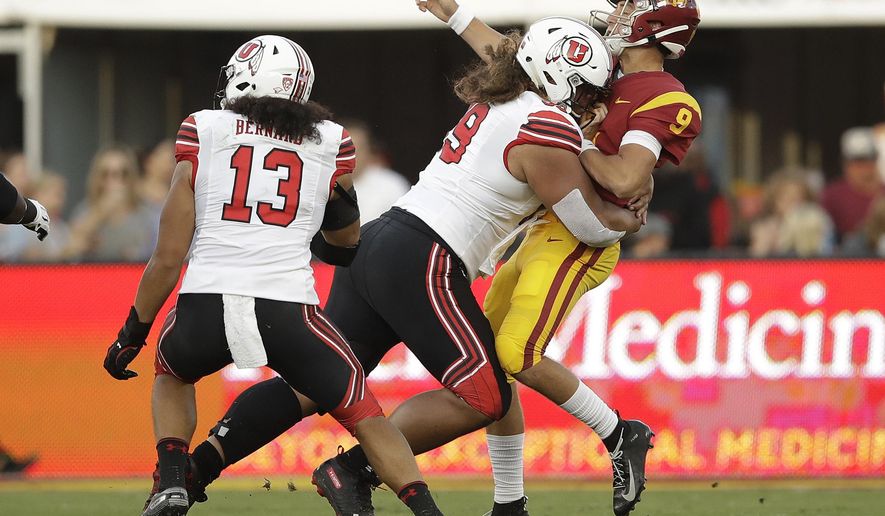 Southern California quarterback Kedon Slovis (9) is hit by by Utah defensive tackle Leki Fotu during the first half of an NCAA college football game Friday, Sept. 20, 2019, in Los Angeles. (AP Photo/Marcio Jose Sanchez)