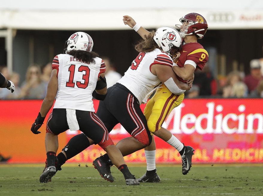 Southern California quarterback Kedon Slovis (9) is hit by by Utah defensive tackle Leki Fotu during the first half of an NCAA college football game Friday, Sept. 20, 2019, in Los Angeles. (AP Photo/Marcio Jose Sanchez)