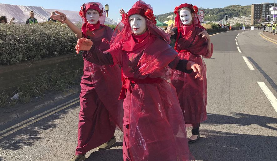 Members of Extinction Rebellion climate protester group occupy one side of a dual carriageway at the Port of Dover, Dover, England. Saturday Sept. 21, 2019. Two lanes at the busy Kent port have been fenced off and taken over by the environmental activists amid a heavy police presence. (Michael Drummond/PA via AP)(/PA via AP)