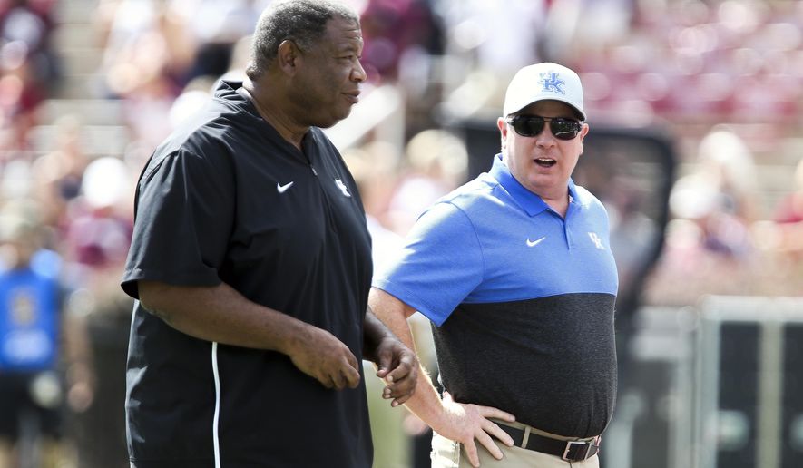 Kentucky head coach Mark Stoops talks with Kentucky associate head coach Vince Marrow during warmups prior to an NCAA college football game against Mississippi State, Saturday, Sept. 21, 2019, in Starkville, Miss. (AP Photo/Kelly Donoho)