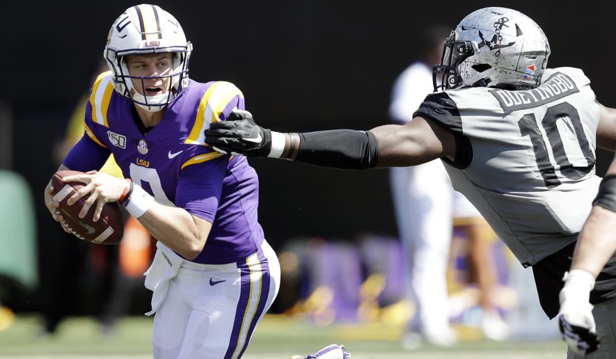LSU quarterback Joe Burrow, left, scrambles away from Vanderbilt defensive lineman Dayo Odeyingbo (10) in the first half of an NCAA college football game Saturday, Sept. 21, 2019, in Nashville, Tenn. (AP Photo/Mark Humphrey)