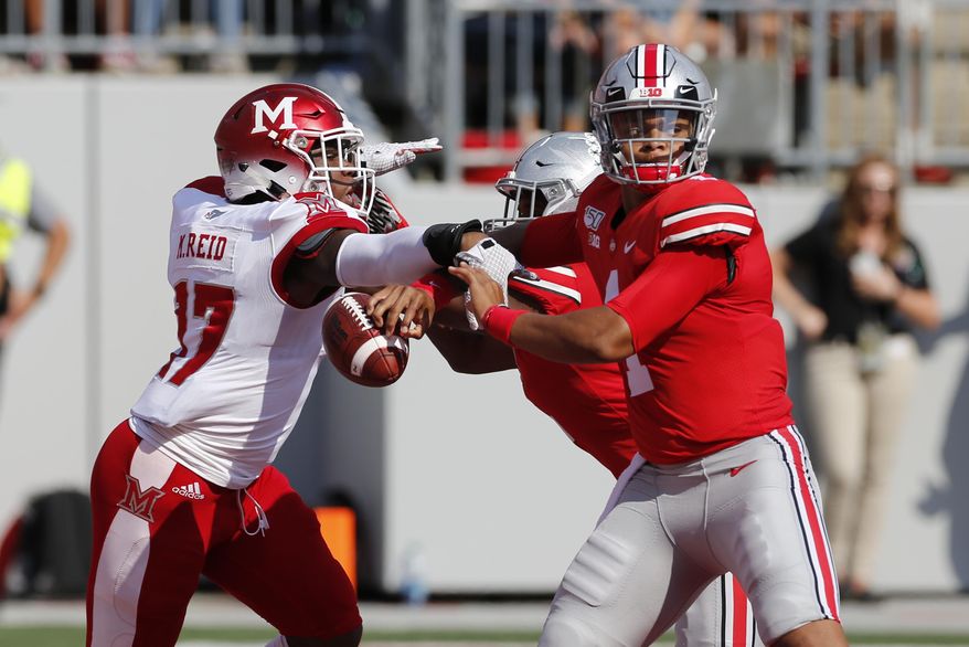 Miami (Ohio) linebacker Myles Reid, left, knocks the ball away from Ohio State quarterback Justin Fields, causing a fumble and a safety, during the first half of an NCAA college football game Saturday, Sept. 21, 2019, in Columbus, Ohio. (AP Photo/Jay LaPrete)