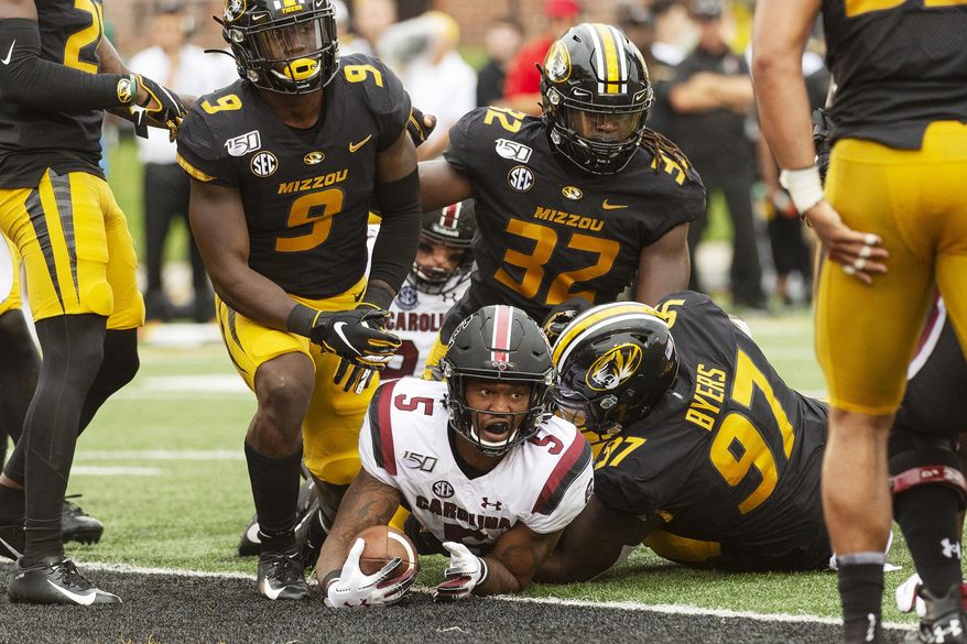 South Carolina running back Rico Dowdle, bottom, looks up after he scored a touchdown past Missouri's Tyree Gillespie, left, Akial Byers, right, and Nick Bolton, top, during the second quarter of an NCAA college football game, Saturday, Sept. 21, 2019, in Columbia, Mo. (AP Photo/L.G. Patterson)