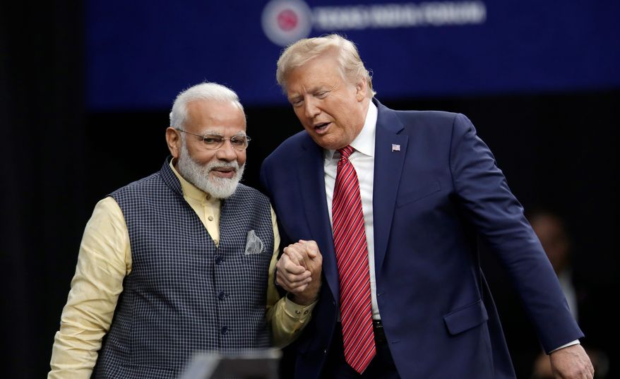 Prime Minister Narendra Modi and President Trump shake hands after introductions during the &quot;Howdy Modi&quot; rally Sunday in Houston. (Associated Press)