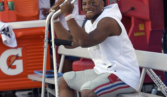 New York Giants running back Saquon Barkley smiles as he sits on the bench during the second half of an NFL football game against the Tampa Bay Buccaneers Sunday, Sept. 22, 2019, in Tampa, Fla. Barkley was injured in the first half. (AP Photo/Jason Behnken)