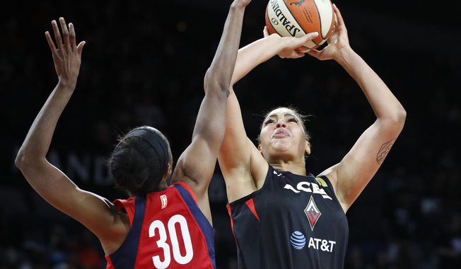 Washington Mystics&#x27; LaToya Sanders, left, fouls Las Vegas Aces&#x27; Liz Cambage during the first half in Game 3 in a semifinal game in the WNBA playoffs, Sunday, Sept. 22, 2019, in Las Vegas. (AP Photo/John Locher)