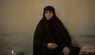 In this Saturday, Sept. 7, 2019, photo, Um Mahmoud recalls her experience returning to Raqqa, Syria, during an interview in the courtyard of her home. After two years on the run with the Islamic State group, Um Mahmoud was ready to return home. In June, she finally made it back to Raqqa with her three daughters and three grandchildren -- finding an empty, partially burned house and a hostile city. (AP Photo/Maya Alleruzzo)