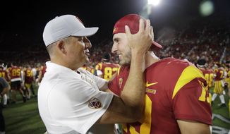 Southern California coach Clay Helton, left, hugs quarterback Matt Fink after the team&#39;s 30-23 win over Utah in an NCAA college football game Friday, Sept. 20, 2019, in Los Angeles. (AP Photo/Marcio Jose Sanchez)