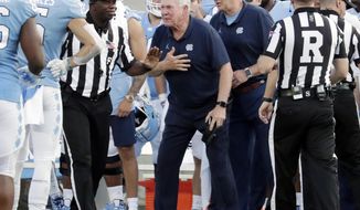 North Carolina head coach Mack Brown, center, argues a call with the officials during the third quarter of an NCAA college football game against Appalachian State in Chapel Hill, N.C., Saturday, Sept. 21, 2019. (AP Photo/Chris Seward)