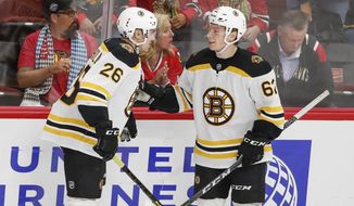 Boston Bruins center Oskar Steen, right, celebrates with center Par Lindholm, left, after scoring against the Chicago Blackhawks during the third period of a preseason NHL hockey game Saturday, Sept. 21, 2019, in Chicago. (AP Photo/Kamil Krzaczynski)