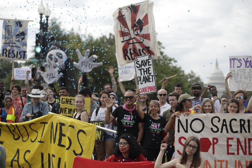Protesters block traffic near the U.S. Capitol in Washington, Monday, Sept. 23, 2019. A broad coalition of climate and social justice organizations are disrupting the morning rush hour commute. (AP Photo/Pablo Martinez Monsivais)
