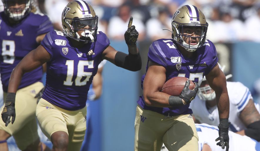 Washington linebacker Brandon Wellington (13), runs the ball in for a touchdown after he recovered a fumble as Washington defensive back Cameron Williams (16) celebrates in the first half, during an NCAA college football game, Saturday, Sept. 21, 2019, in Provo, Utah. (AP Photo/George Frey)