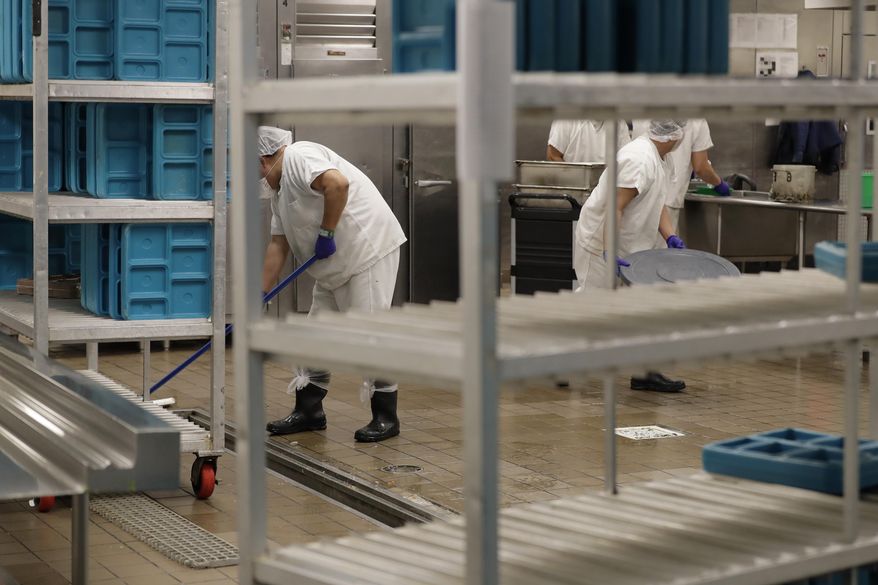 In this photo taken Sept. 10, 2019, workers are shown in the kitchen of the U.S. Immigration and Customs Enforcement (ICE) detention facility in Tacoma, Wash. during a media tour. On Tuesday, Sept. 24, 2019, U.S. District Judge Robert Bryan notified attorneys for Washington state and the GEO Group -- which operates the detention center -- that he plans to dismiss a case in which Washington state was pursuing a claim that immigration detainees must be paid minimum wage for work they perform in custody. (AP Photo/Ted S. Warren)