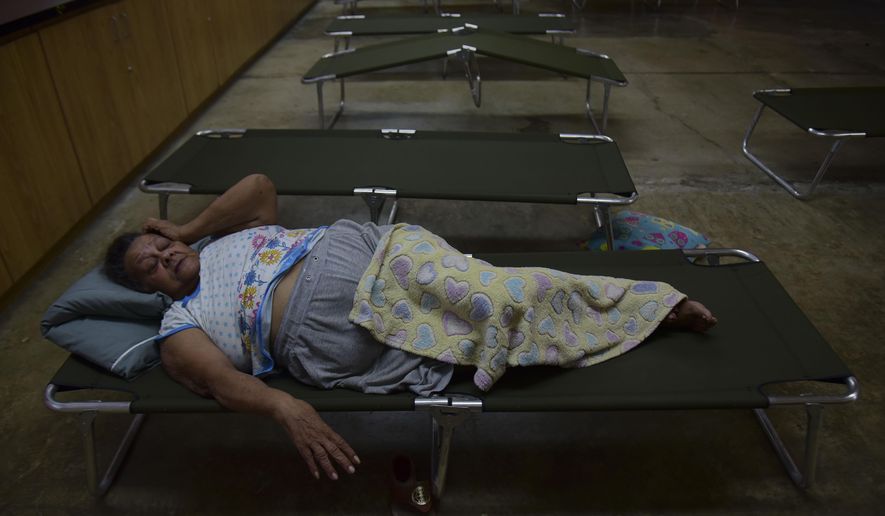 Luz Aponte Velazquez lies on a cot at the Ramon Quinones Medina High School, one of the shelters enabled by the municipality of Yabucoa, before the arrival of Tropical Storm Karen, in Yabucoa, Puerto Rico, Tuesday, Sept. 24, 2019. Tropical Storm Karen regained strength as it swirled toward Puerto Rico, where it&#39;s expected to bring heavy rains and strong winds. (AP Photo/Carlos Giusti)