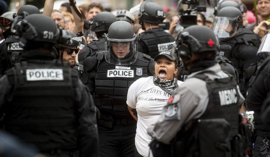 Police officers detain a protester against right-wing demonstrators following an "End Domestic Terrorism" rally in Portland, Ore., on Saturday, Aug. 17, 2019. Although the main protest remained largely peaceful, some skirmishes erupted in the following hours and police detained multiple protesters. (AP Photo/Noah Berger)