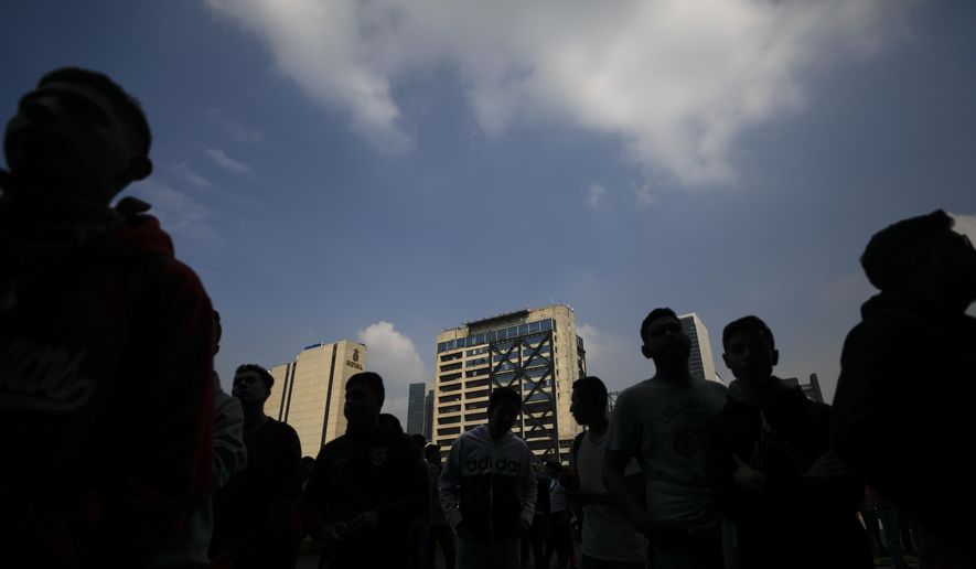 Students listen to family members speak during a protest by parents and relatives of the 43 missing Ayotzinapa teacher's college students, outside the attorney general's office in Mexico City, Wednesday, Sept. 25, 2019. As the families continue to call for justice as they mark Thursday the five year anniversary of their children's disappearance, authorities began searching a new location in Guerrero state.(AP Photo/Rebecca Blackwell)