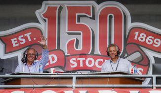 Cincinnati Reds radio announcer Marty Brennaman, left, waves next to his son Thom, in a special outside booth before the Reds&#39; baseball game against the Milwaukee Brewers, Wednesday, Sept. 25, 2019, in Cincinnati. (AP Photo/John Minchillo)
