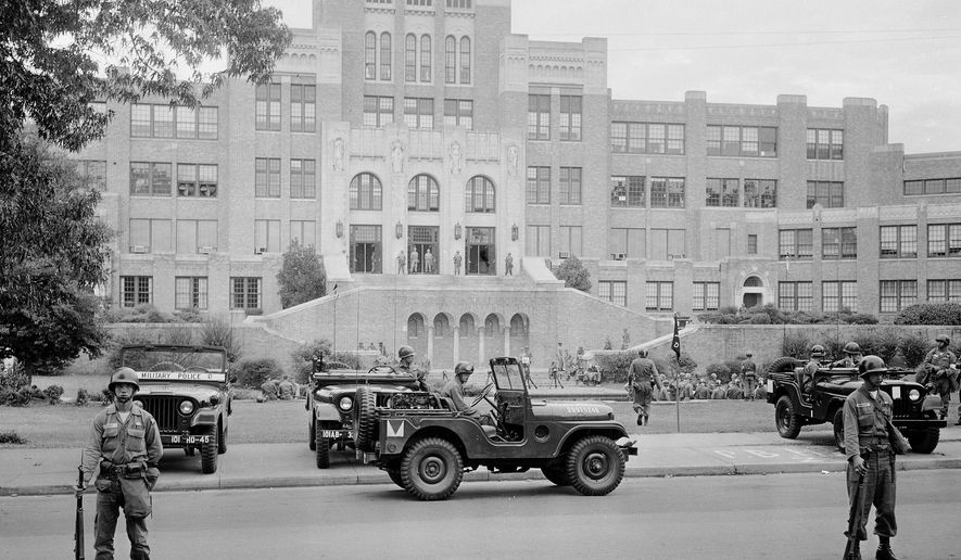 FILE - In this Sept. 26, 1957 file photo, members of the 101st Airborne Division take up positions outside Central High School in Little Rock, Ark. A plan to only grant Little Rock partial control of its schools is drawing complaints that the district may further segregate 62 years after nine black students were escorted into an all-white high school, and a push to end the local teachers union's bargaining power is stirring fears of even more instability. (AP Photo, File)