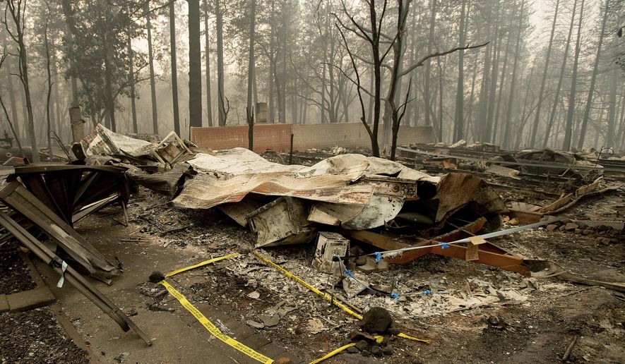 FILE - In this Wednesday, Nov. 14, 2018 file photo, tape marks a spot where sheriff's deputies recovered the body of a Camp Fire victim in Paradise, Calif. The body count from California's deadliest wildfire is back down to 85 after authorities determined that a bone fragment previously classified as "unidentified" belongs to a victim named back in January. The Butte County Sheriff's office said Wednesday, Sept. 25 2019 that the number of unidentified victims from the November 2018 Camp Fire now stands at one (AP Photo/Noah Berger, File)