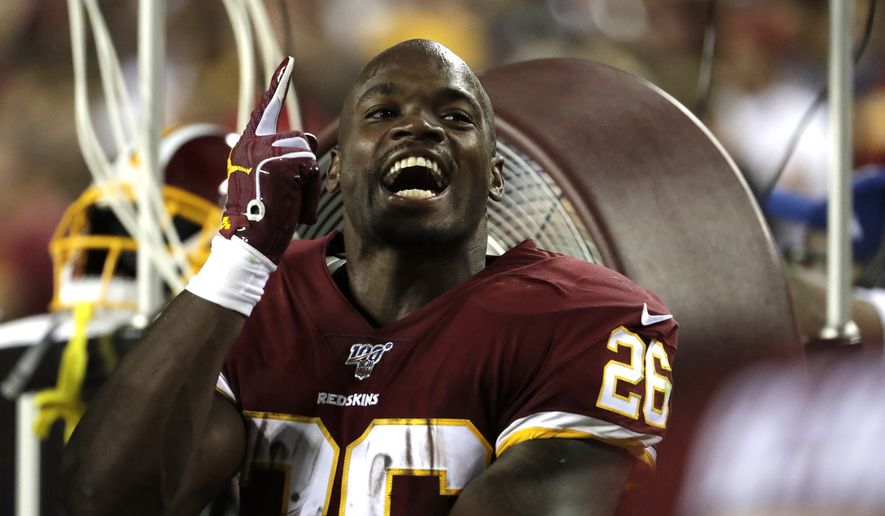 Washington Redskins running back Adrian Peterson talks to teammates on the bench during the first half of an NFL football game against the Chicago Bears Monday, Sept. 23, 2019, in Landover, Md. (AP Photo/Julio Cortez) **FILE**