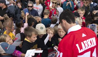 Detroit Red Wings player Dylan Larkin signs autographs for fans outside the Calumet Colosseum on Thursday, Sept. 26, 2019, in Calumet, Mich. The Colosseum, built in 1913 and the oldest continuously used indoor ice arena in the world, hosts an NHL preseason game between Red Wings and St. Louis Blues on Thursday night. (Adam Niemi/The Daily Mining Gazette via AP)